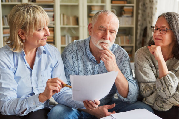 Female financial advisor talking to elderly couple about funeral trust policies