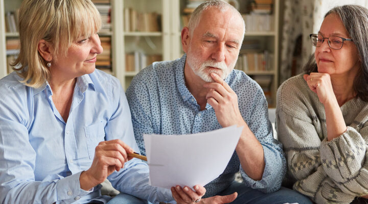 Female financial advisor talking to elderly couple about funeral trust policies