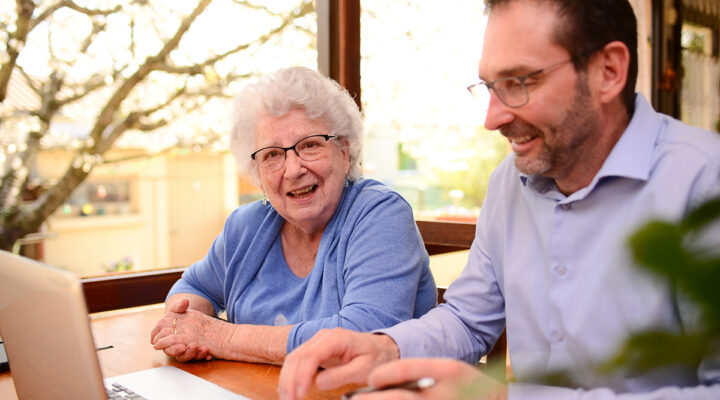 mature man helping elderly senior woman at home with advanced estate planning